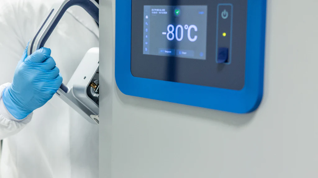Researcher opening an ultra-low-temperature laboratory freezer displaying minus 80 degrees Celsius
